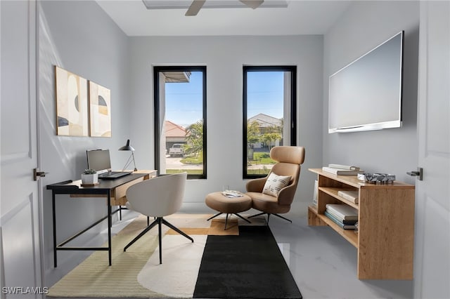 home office with ceiling fan and concrete floors