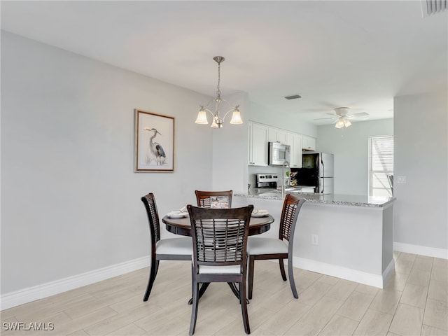 dining space featuring ceiling fan with notable chandelier