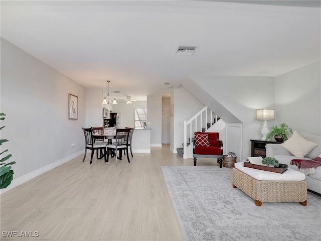 living room featuring light hardwood / wood-style flooring and an inviting chandelier