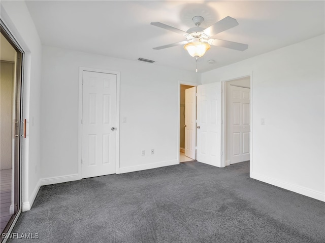 unfurnished bedroom featuring dark colored carpet and ceiling fan