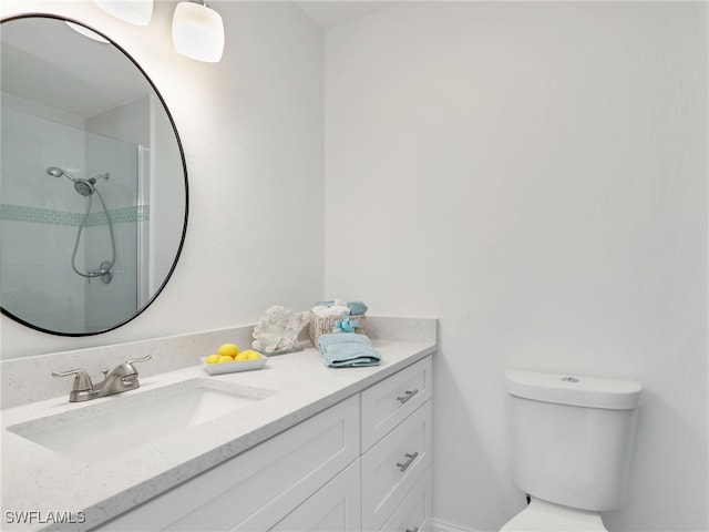 bathroom featuring tiled shower, vanity, and toilet