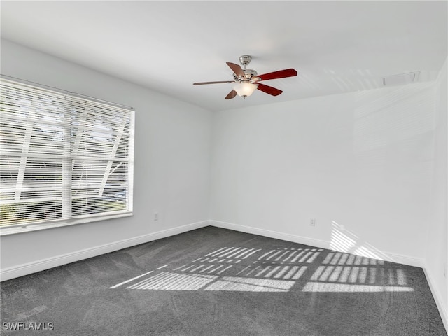 carpeted spare room featuring ceiling fan