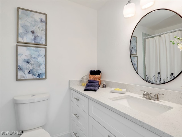 bathroom featuring toilet, vanity, and walk in shower