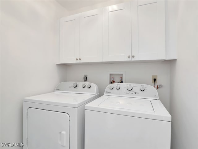 laundry area with washer and dryer and cabinets