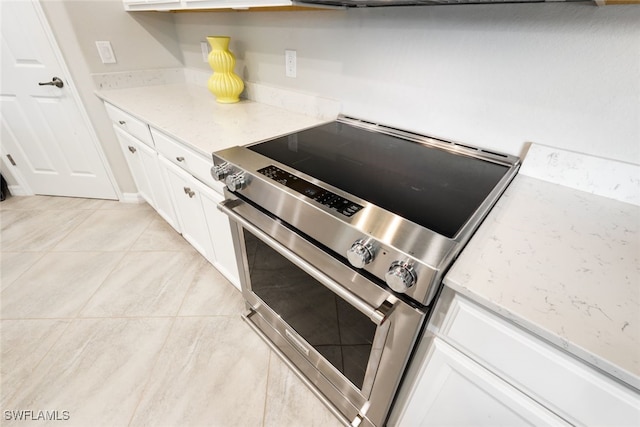 kitchen featuring white cabinetry, light stone counters, and electric stove