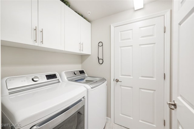 clothes washing area featuring independent washer and dryer and cabinets