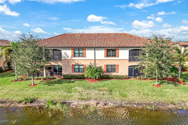 rear view of property with a water view and a yard