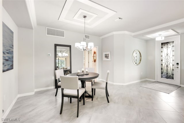 dining area featuring ornamental molding, a tray ceiling, and a notable chandelier