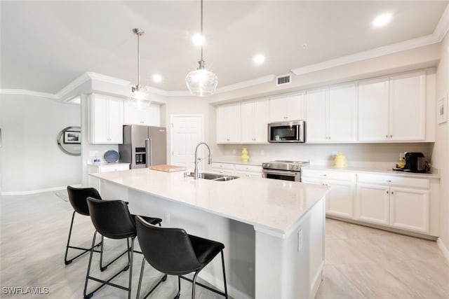 kitchen featuring appliances with stainless steel finishes, white cabinetry, hanging light fixtures, and sink