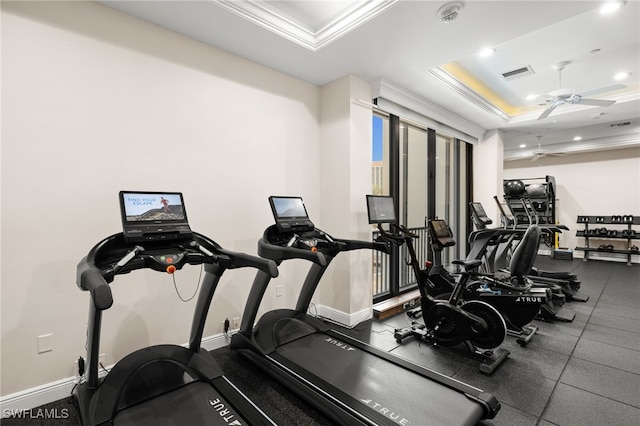 gym featuring a tray ceiling, ceiling fan, and crown molding