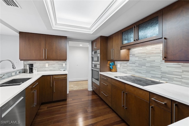 kitchen featuring a raised ceiling, decorative backsplash, sink, and appliances with stainless steel finishes