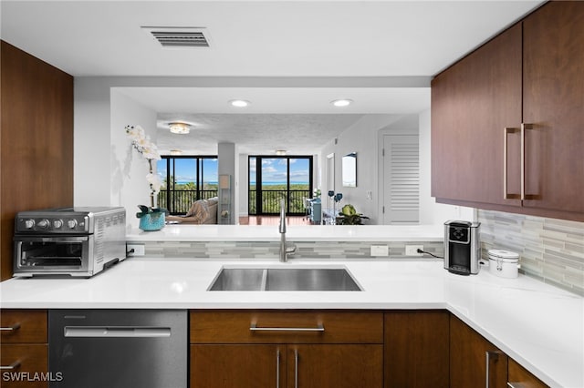 kitchen featuring dishwasher, backsplash, and sink