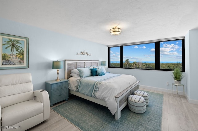 bedroom with a textured ceiling and light wood-type flooring