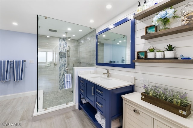 bathroom with a shower with door, vanity, and hardwood / wood-style floors