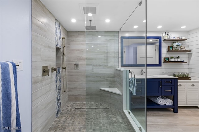 bathroom with vanity and a tile shower