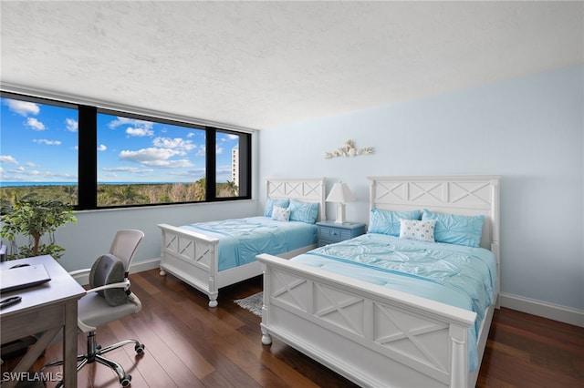 bedroom with a textured ceiling and dark hardwood / wood-style floors