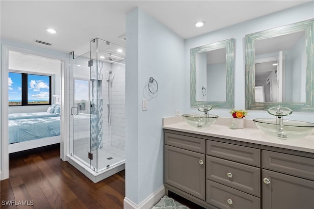 bathroom featuring hardwood / wood-style flooring, vanity, and a shower with door