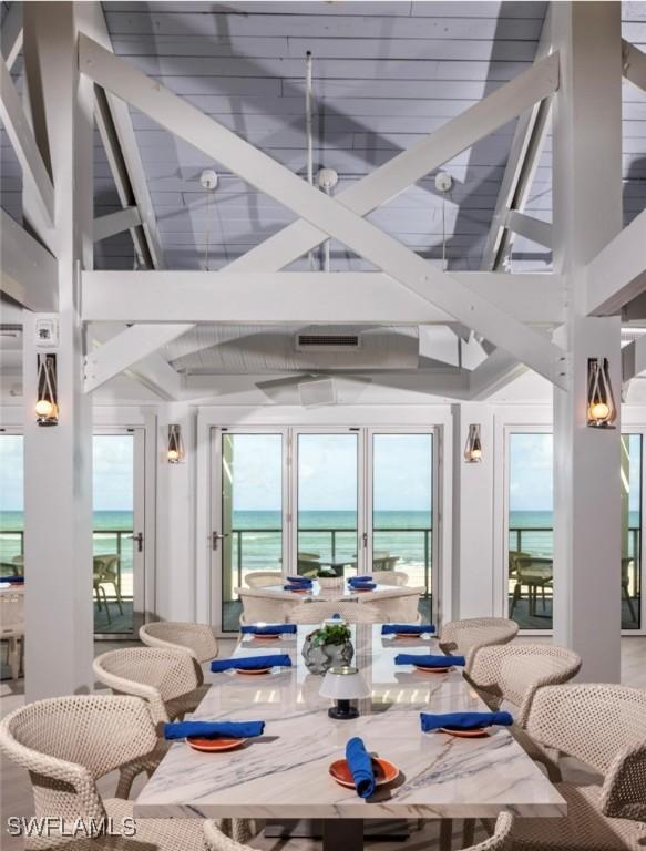 sunroom featuring a wealth of natural light, a water view, and lofted ceiling