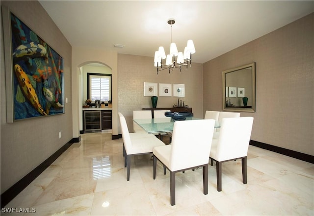 dining area featuring wine cooler and a notable chandelier