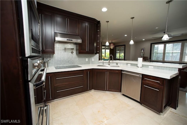 kitchen with kitchen peninsula, stainless steel dishwasher, ceiling fan, sink, and hanging light fixtures