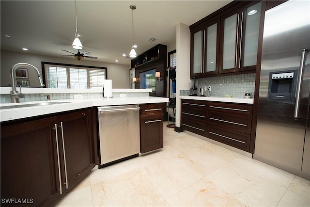 kitchen featuring sink, ceiling fan, decorative light fixtures, dark brown cabinetry, and stainless steel appliances