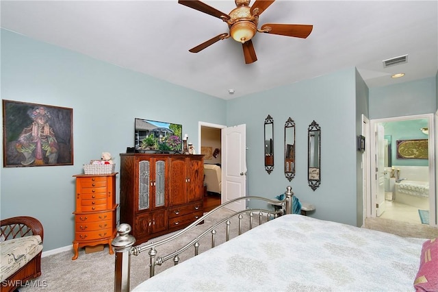 bedroom with ensuite bathroom, carpet floors, and ceiling fan