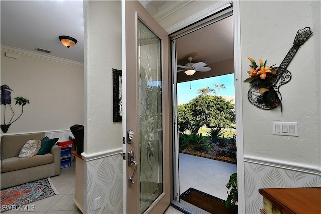 entryway with ornamental molding, light tile patterned flooring, and ceiling fan