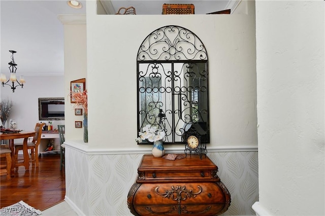 room details with ornamental molding, a chandelier, and hardwood / wood-style floors