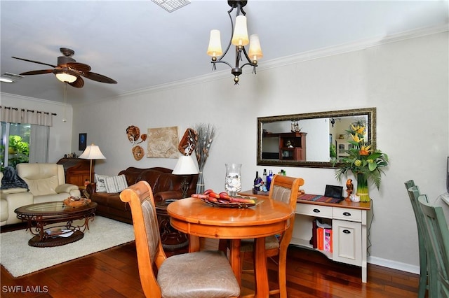 dining area with dark wood-type flooring, crown molding, and ceiling fan with notable chandelier