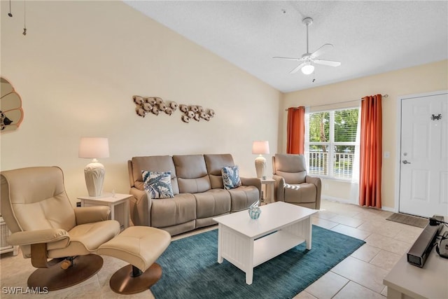 living room featuring a textured ceiling, ceiling fan, light tile patterned floors, and lofted ceiling