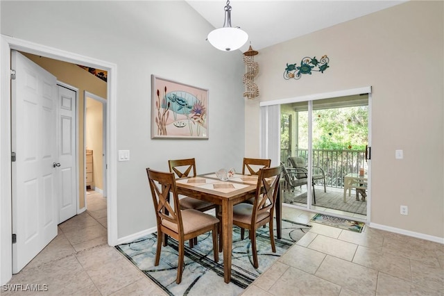 dining space with lofted ceiling and light tile patterned floors