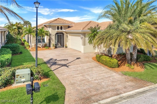 mediterranean / spanish-style house with a garage and a front lawn