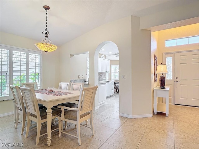 tiled dining area with ceiling fan and lofted ceiling