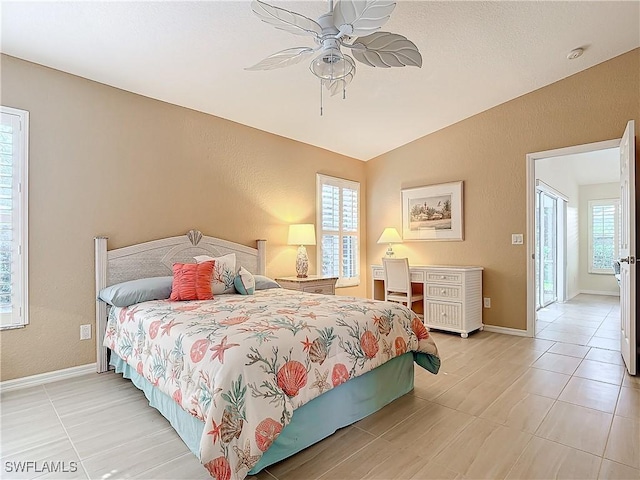 bedroom with ceiling fan, lofted ceiling, and multiple windows