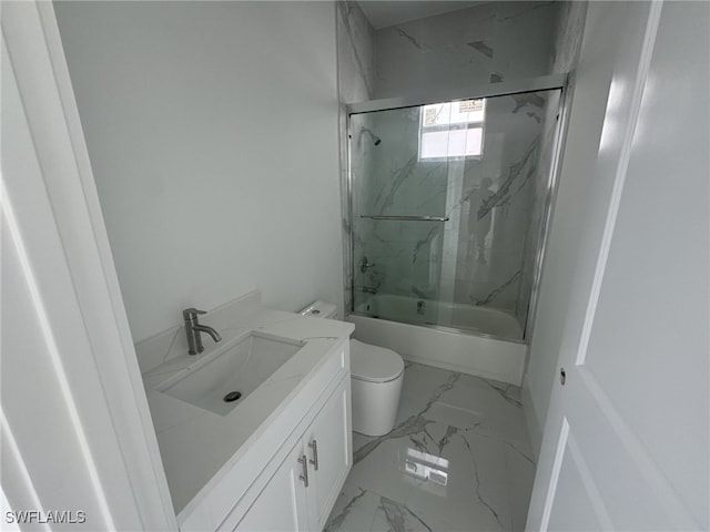 full bathroom with vanity, bath / shower combo with glass door, and toilet