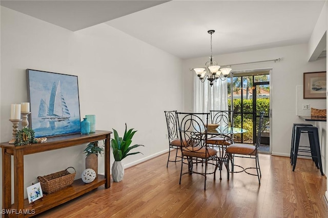 dining room featuring hardwood / wood-style flooring and an inviting chandelier