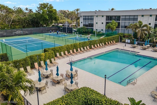 view of swimming pool with tennis court