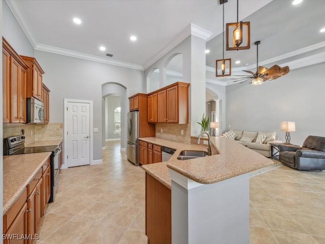 kitchen with kitchen peninsula, sink, stainless steel appliances, and ornamental molding