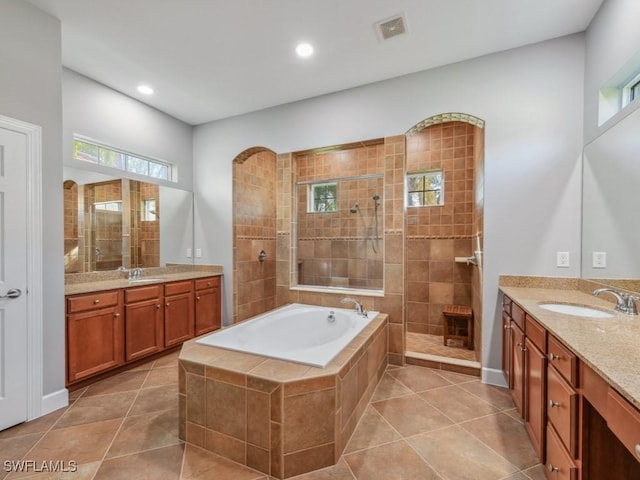 bathroom featuring tile patterned flooring, vanity, and shower with separate bathtub