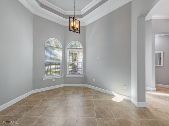 tiled empty room with a raised ceiling, crown molding, and a notable chandelier