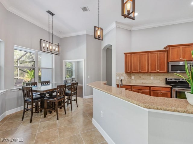 kitchen featuring backsplash, stainless steel appliances, hanging light fixtures, and an inviting chandelier