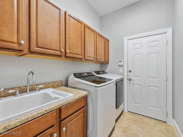 washroom with cabinets, independent washer and dryer, sink, and light tile patterned floors