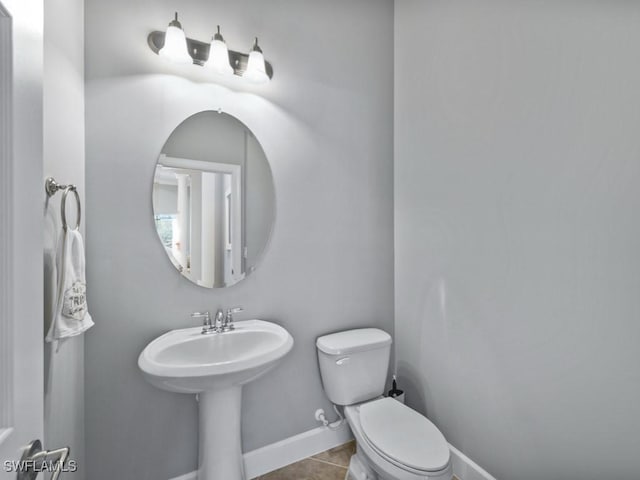 bathroom with tile patterned flooring, toilet, and sink