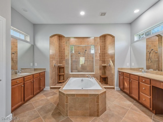 bathroom featuring plus walk in shower, vanity, and tile patterned floors