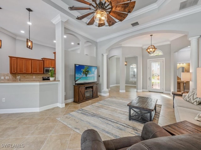 tiled living room featuring crown molding and ceiling fan with notable chandelier