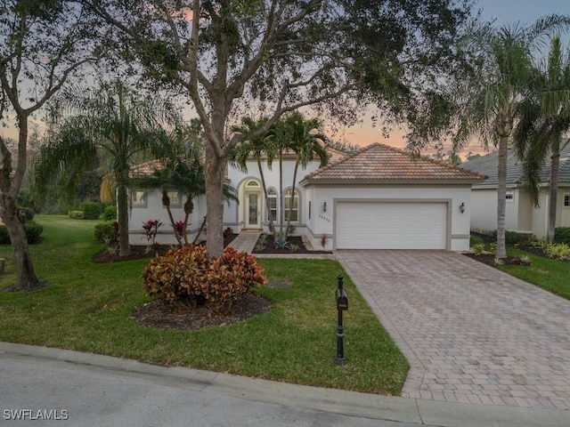 view of front of home with a lawn and a garage