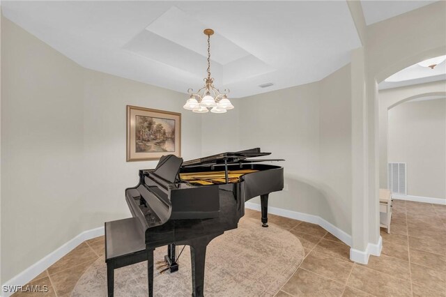 miscellaneous room featuring light tile patterned floors, a tray ceiling, and an inviting chandelier