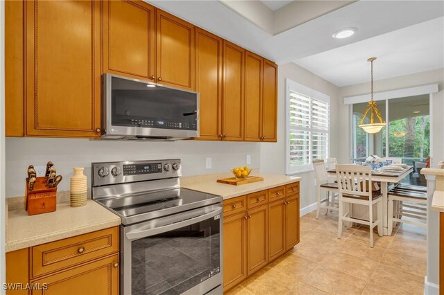 kitchen featuring pendant lighting, light tile patterned flooring, and stainless steel appliances