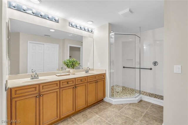 bathroom featuring a shower with door, vanity, and tile patterned flooring