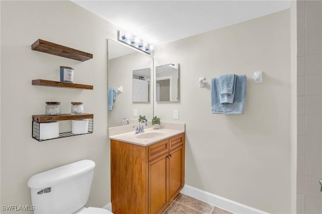 bathroom featuring tile patterned flooring, vanity, and toilet